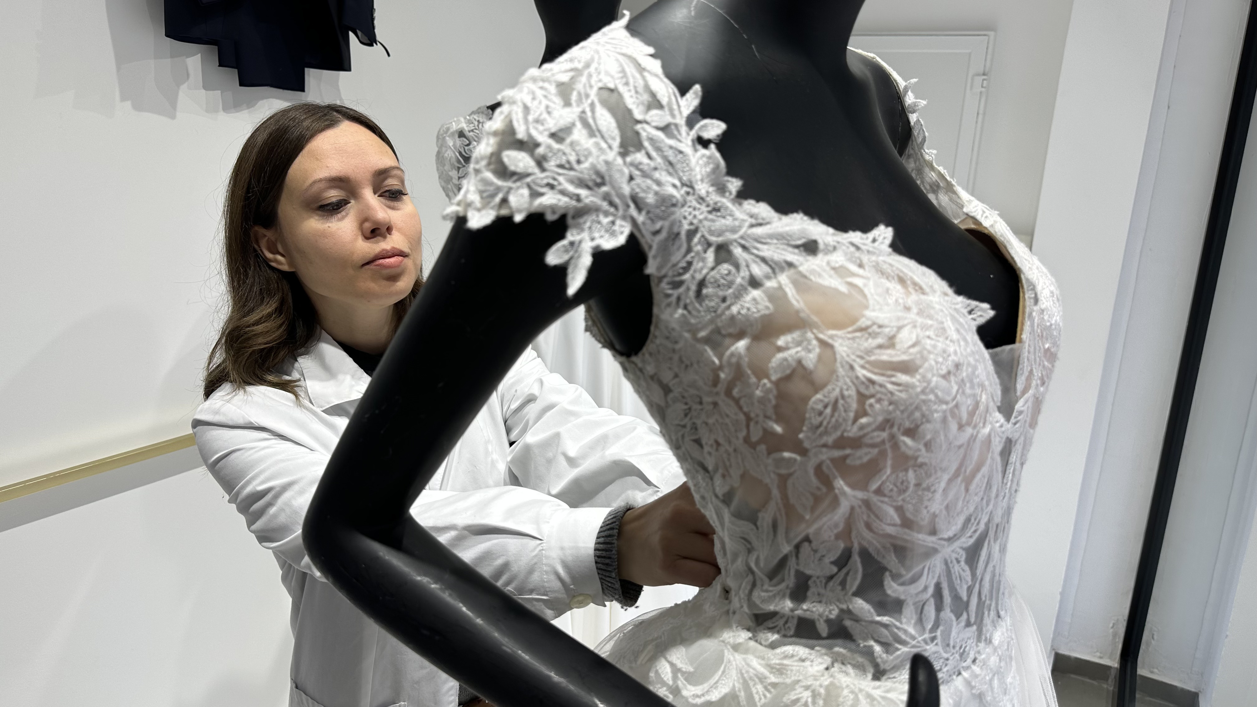 Ana Caroline adjusts a dress in the window